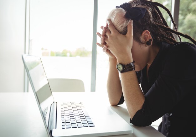 Mujer estresada usando laptop