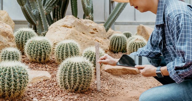 Mujer estudiando diferentes plantas con una tableta