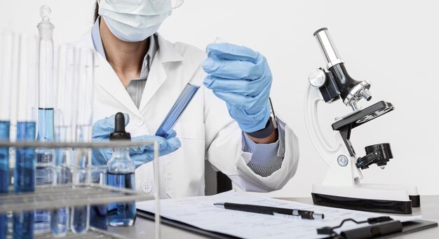 Mujer estudiando elementos químicos mientras usa una mascarilla