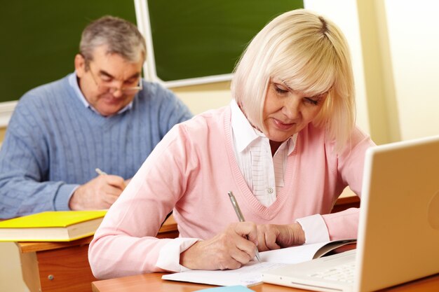 Mujer estudiando con su marido de fondo