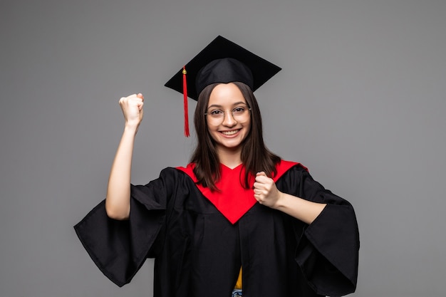 Mujer estudiante graduada con toga y sombrero de graduación, aislado en blanco