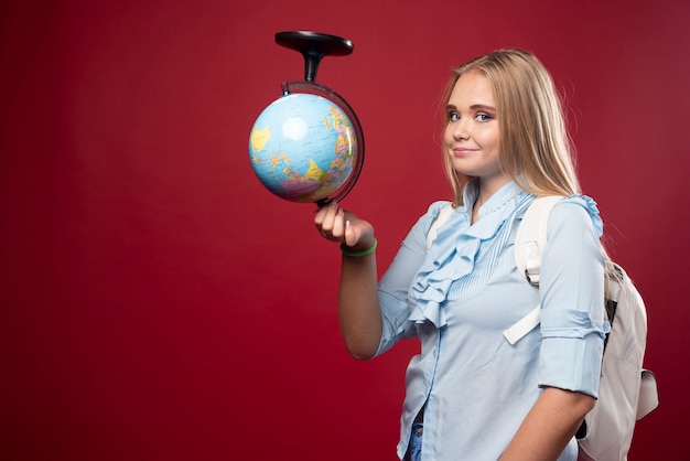 Foto gratuita mujer estudiante rubia sostiene un globo al revés.