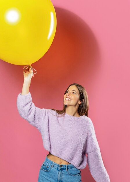 Mujer en estudio divirtiéndose con globos