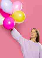 Foto gratuita mujer en estudio divirtiéndose con globos