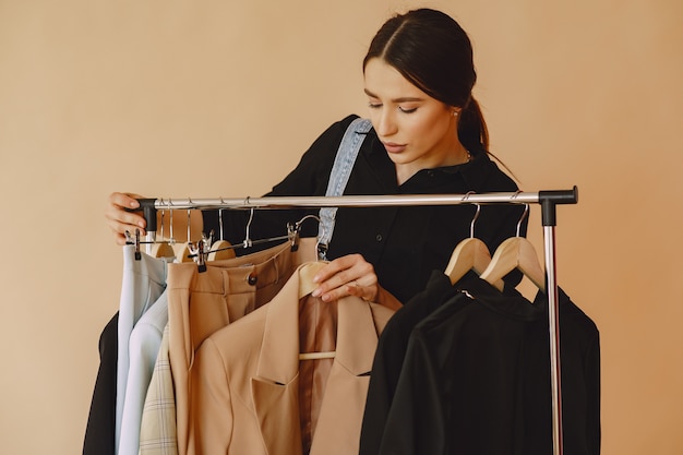 Mujer en un estudio con mucha ropa