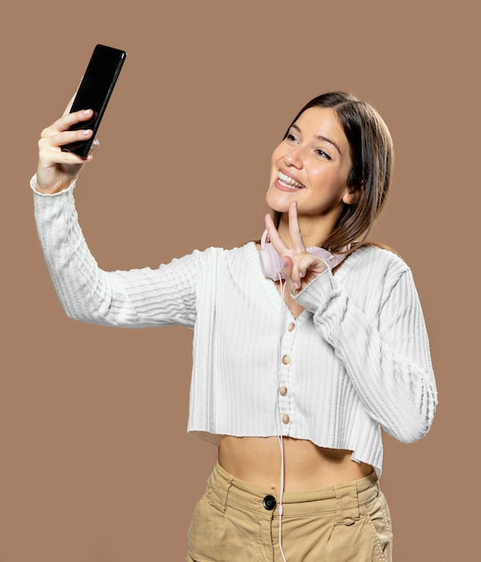 Mujer en estudio tomando una foto del uno mismo