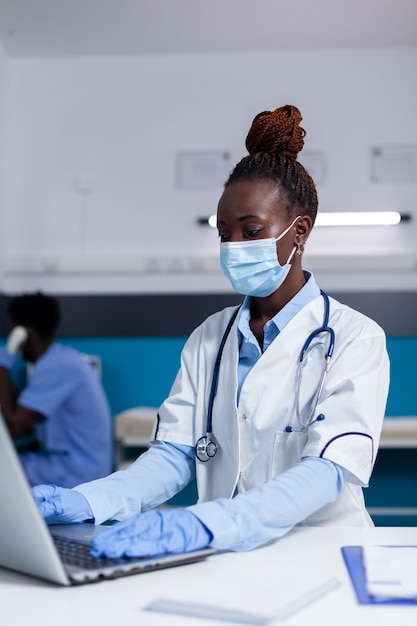 Mujer de etnia africana trabajando como médico en gabinete médico