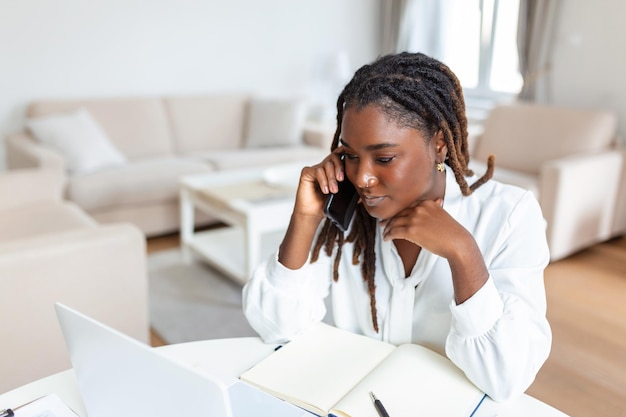 Foto gratuita una mujer de etnia afroamericana con el ceño fruncido se sienta en el escritorio del lugar de trabajo mira la pantalla del portátil lee el correo electrónico se siente preocupada aburrido desmotivado problemas de empleados cansados dificultades con la aplicación