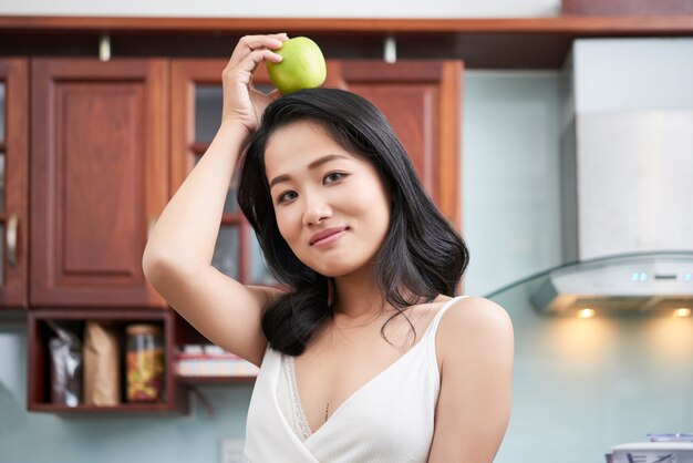 Mujer étnica con manzana en la cabeza.