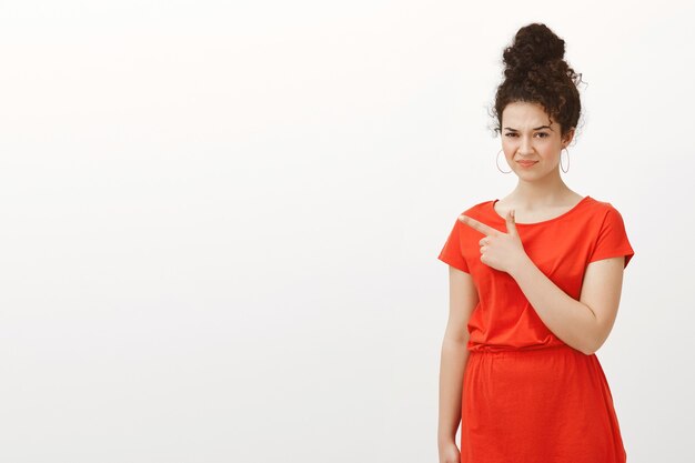 Mujer europea disgustada en elegante vestido rojo casual