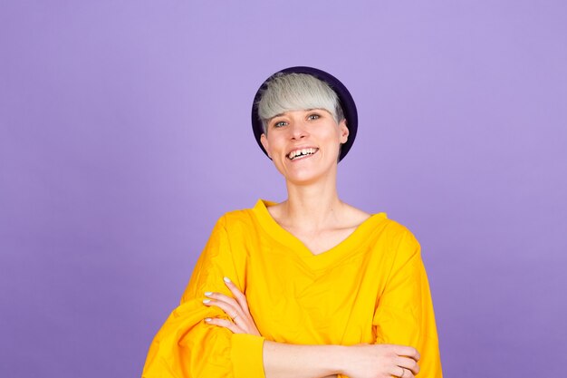 Mujer europea con estilo en la pared púrpura. Cara feliz sonriendo con los brazos cruzados mirando a la cámara