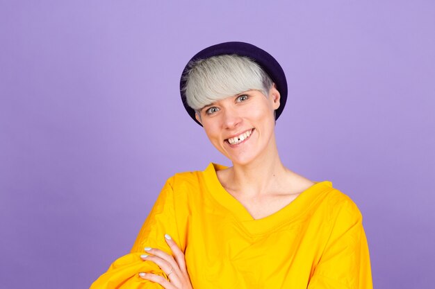 Mujer europea con estilo en la pared púrpura. Cara feliz sonriendo con los brazos cruzados mirando a la cámara