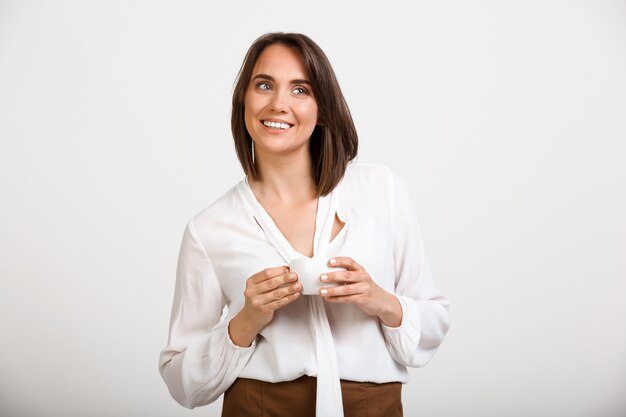 Mujer exitosa beber café y sonriendo