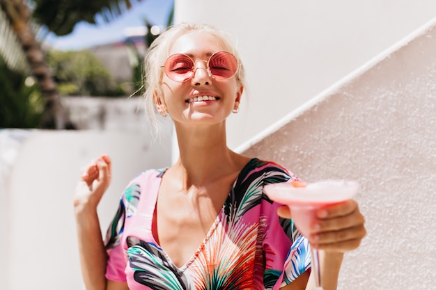 mujer con expresión de cara feliz sonriendo con piel bronceada divirtiéndose.