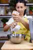 Foto gratuita mujer exprimiendo la leche de almendras de almendras en la cocina de casa