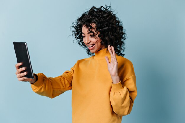 Mujer extática agitando la mano durante la videollamada