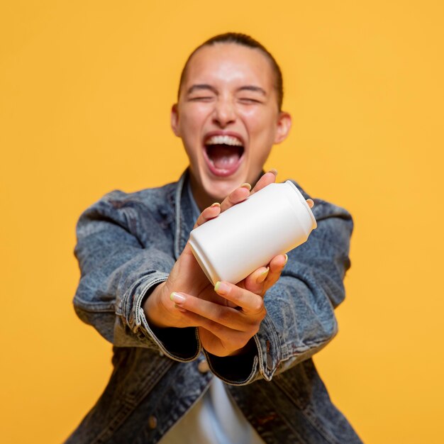 Mujer extática sosteniendo lata de refresco