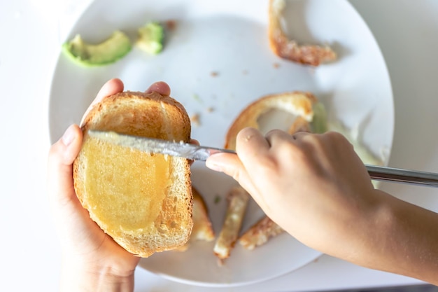 Foto gratuita mujer extendiendo mermelada sobre una tostada sobre la mesa