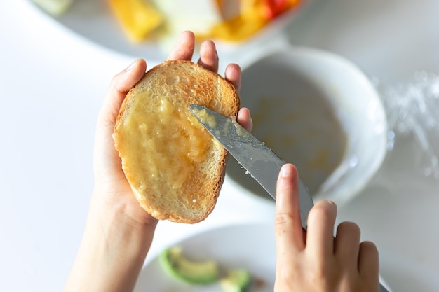 Foto gratuita mujer extendiendo mermelada en tostadas sobre la mesa