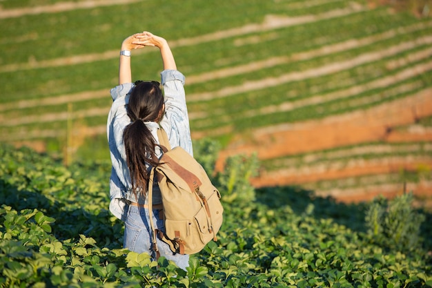 Mujer extendió los brazos en la granja de fresas