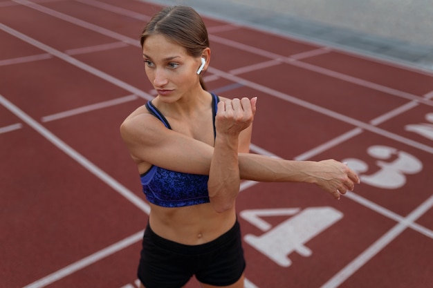 mujer, extensión, en, atletismo, pista, alto, ángulo