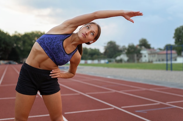 mujer, extensión, en, atletismo, pista, vista delantera