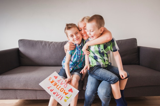 Mujer feliz abrazando a sus hijos en el día de la madre