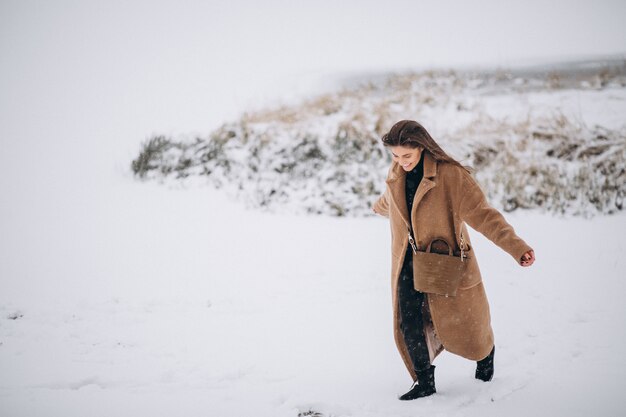 Mujer feliz en abrigo en invierno afuera en el parque