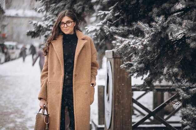 Mujer feliz en abrigo en invierno afuera