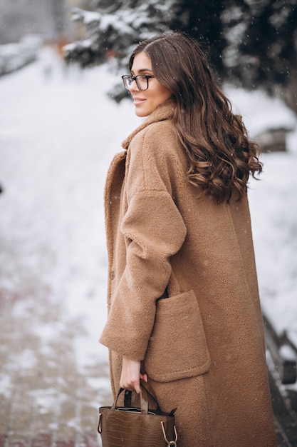 Mujer feliz en abrigo en invierno afuera