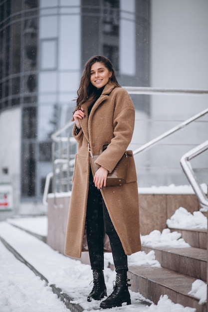 Mujer feliz en abrigo en invierno afuera