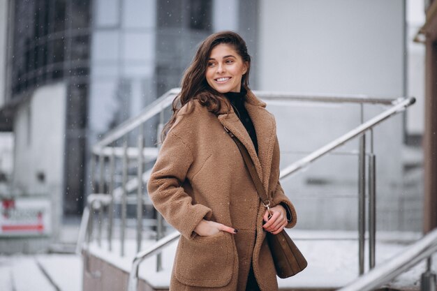 Mujer feliz en abrigo en invierno afuera
