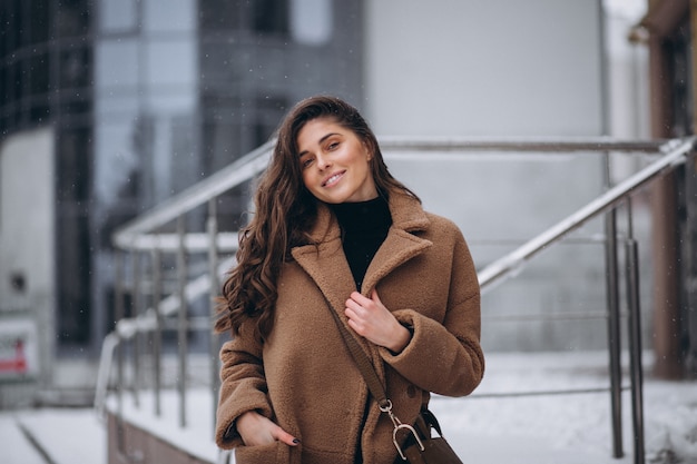 Mujer feliz en abrigo en invierno afuera