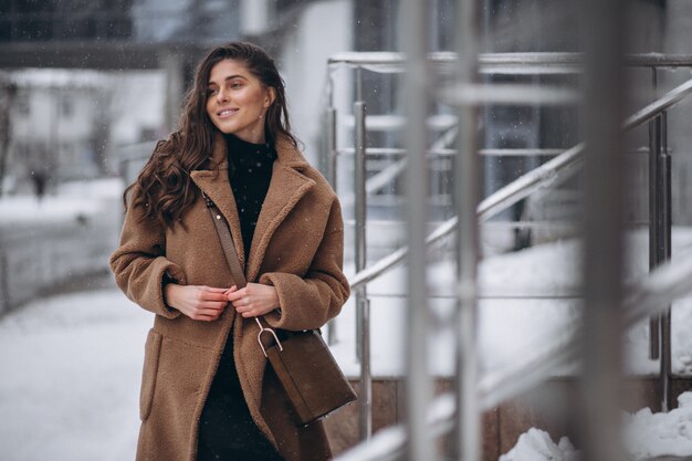 Mujer feliz en abrigo en invierno afuera