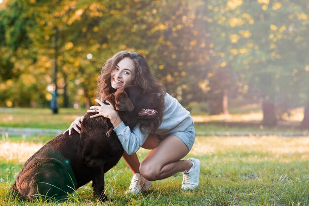 Mujer feliz amando a su perro en el jardín