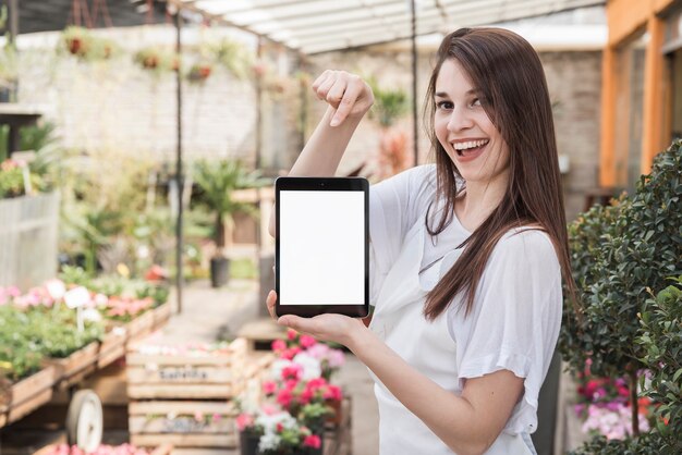 Mujer feliz apuntando a la tableta digital con pantalla en blanco en blanco