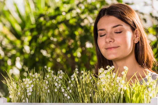 Mujer feliz atractiva cerca de las plantas frescas