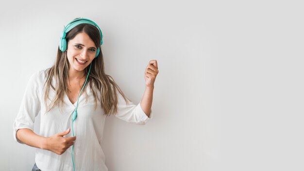 Mujer feliz bailando con los cascos puestos