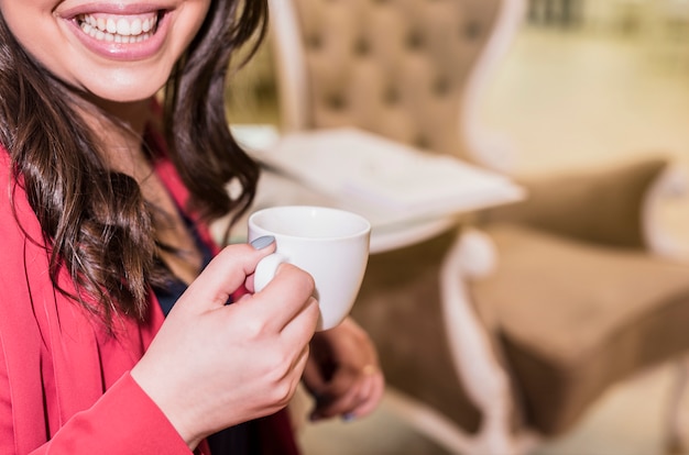 Foto gratuita mujer feliz bebiendo cafe
