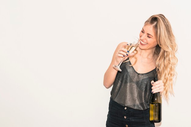 Mujer feliz bebiendo champán de vidrio