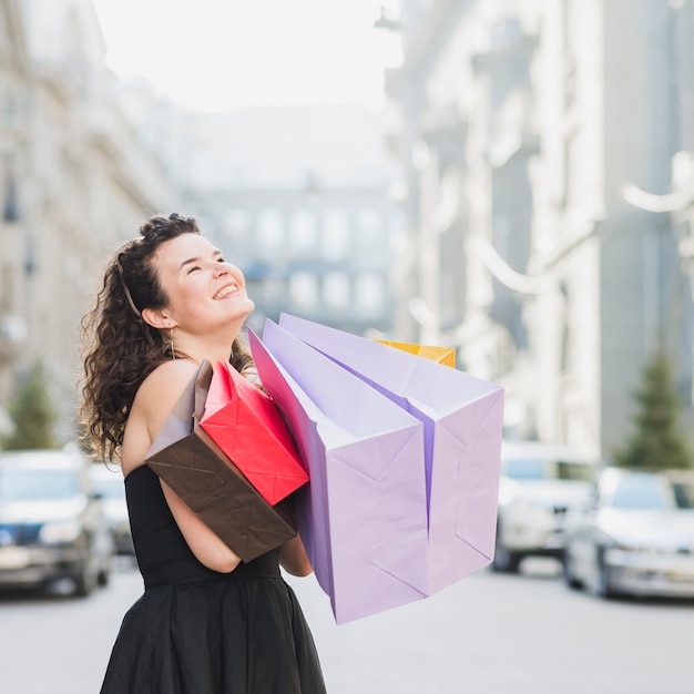 Mujer feliz con bolsas de compras multicolores