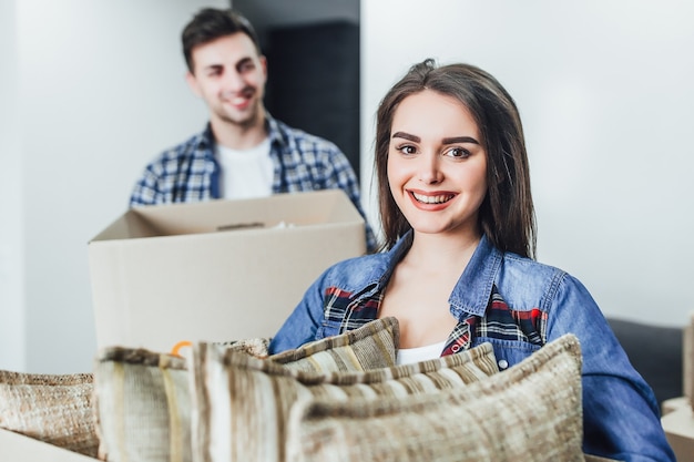 Mujer feliz con caja en manos en casa nueva