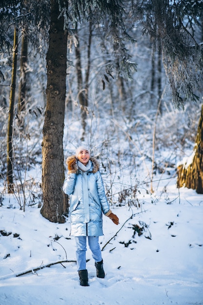 Mujer feliz caminando en un parque de invierno