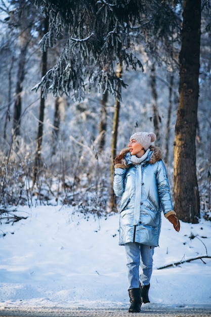 Mujer feliz caminando en un parque de invierno