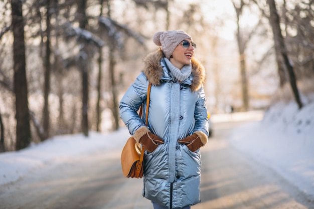 Mujer feliz caminando en un parque de invierno