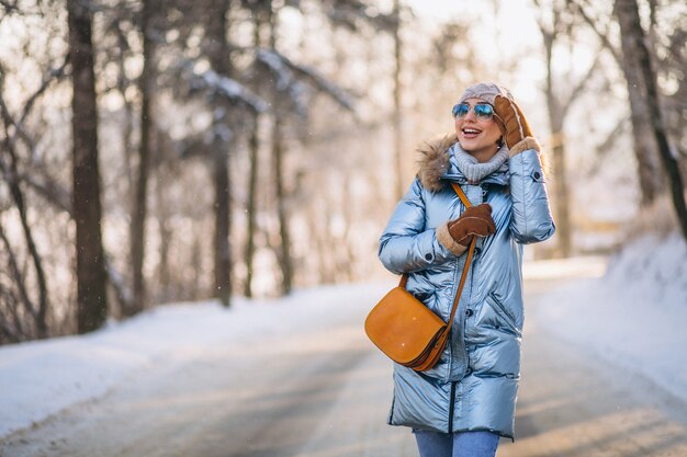 Mujer feliz caminando en un parque de invierno