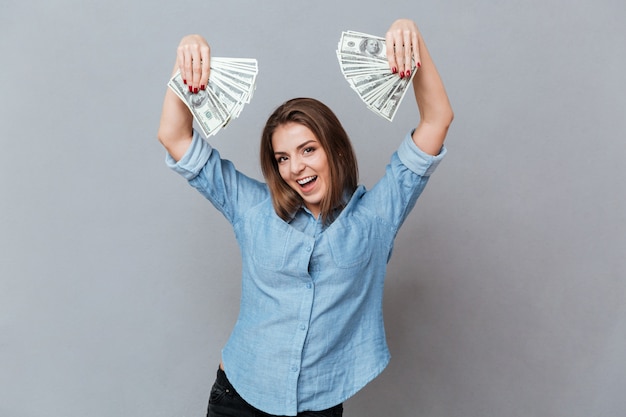 Foto gratuita mujer feliz en camisa con dinero en manos