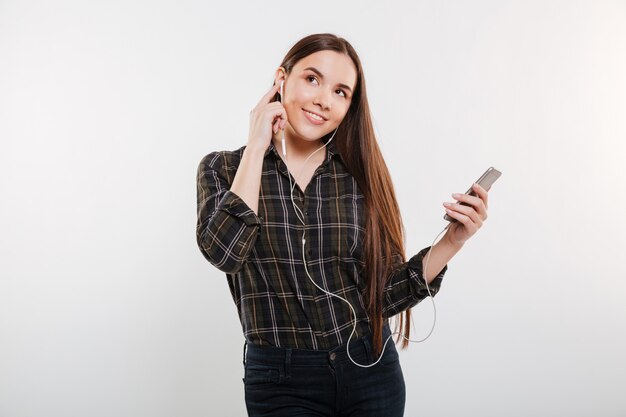 Mujer feliz en camisa escuchando música en el teléfono