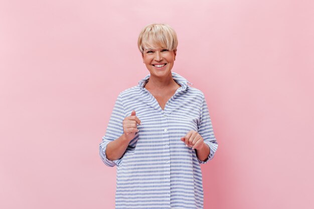 Mujer feliz en camisa mira con sonrisa a la cámara