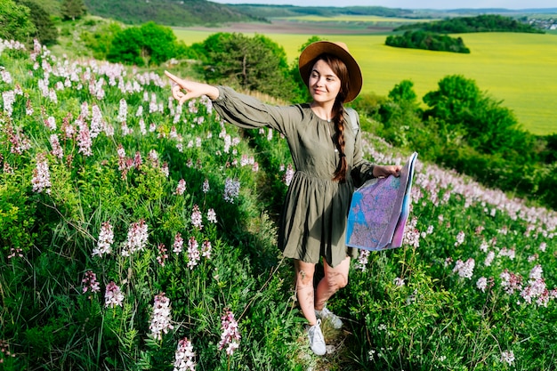 Mujer feliz en campo con mapa